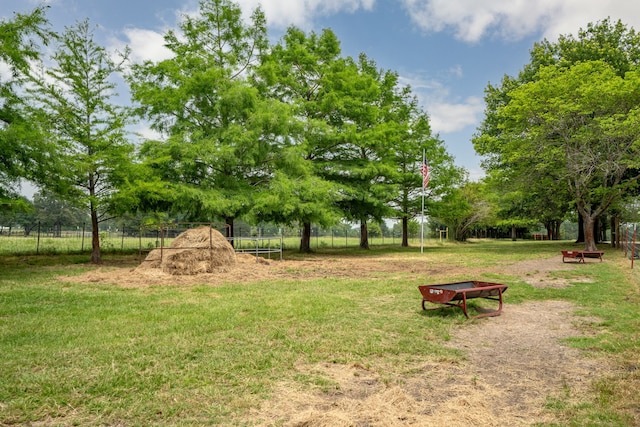 view of property's community featuring a trampoline and a lawn