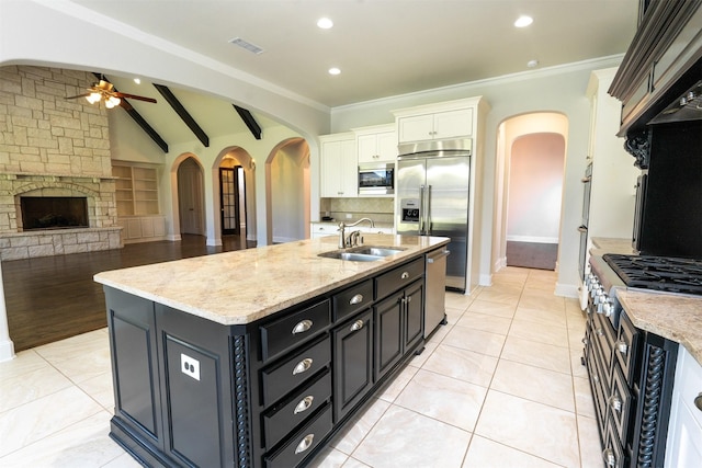 3019 Haywick, The Colony, TX 75056 - kitchen with arched walkways, a sink, built in appliances, ceiling fan, and white cabinets