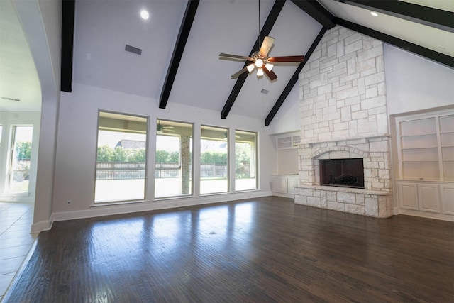 3019 Haywick, The Colony, TX 75056 - unfurnished living room featuring ceiling fan, a stone fireplace, baseboards, plenty of natural light, and beamed ceiling