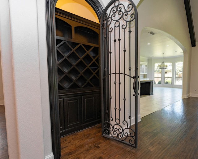 3019 Haywick, The Colony, TX 75056 - wine cellar featuring arched walkways, dark wood-style floors, a chandelier, and baseboards