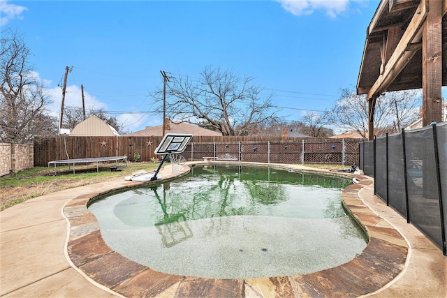 view of swimming pool featuring a trampoline and a patio area