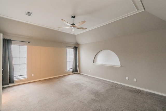 carpeted empty room featuring a ceiling fan, lofted ceiling, visible vents, and baseboards