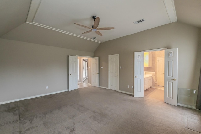 unfurnished bedroom featuring baseboards, visible vents, lofted ceiling, ensuite bathroom, and carpet flooring