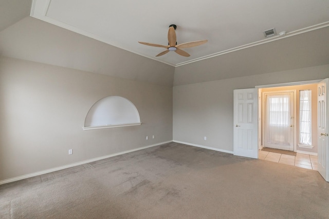 empty room with lofted ceiling, light colored carpet, visible vents, a ceiling fan, and baseboards