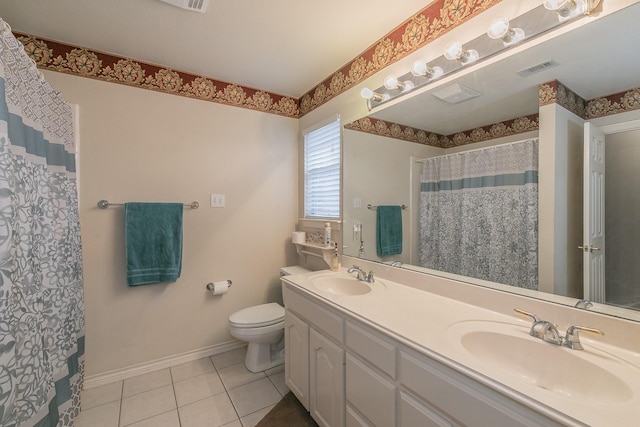 full bathroom with double vanity, tile patterned flooring, a sink, and baseboards