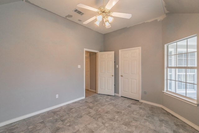 unfurnished room with lofted ceiling, visible vents, baseboards, and a ceiling fan