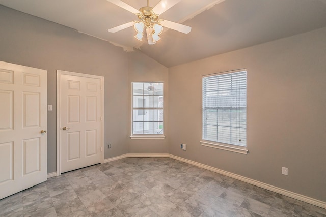 unfurnished room featuring vaulted ceiling, ceiling fan, and baseboards