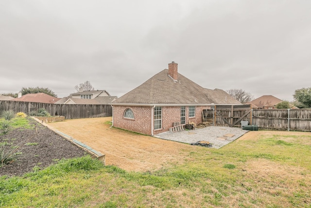 rear view of property featuring a fenced backyard, brick siding, roof with shingles, a lawn, and a chimney