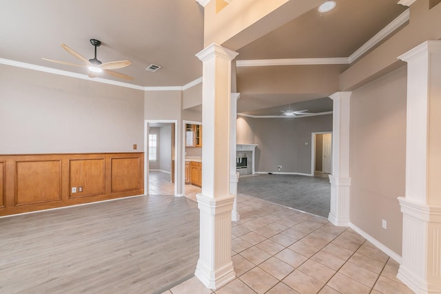 empty room featuring crown molding, visible vents, ceiling fan, and ornate columns