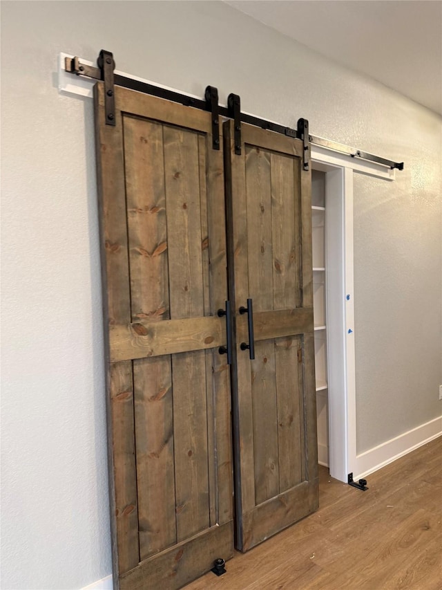 interior details featuring wood-type flooring and a barn door