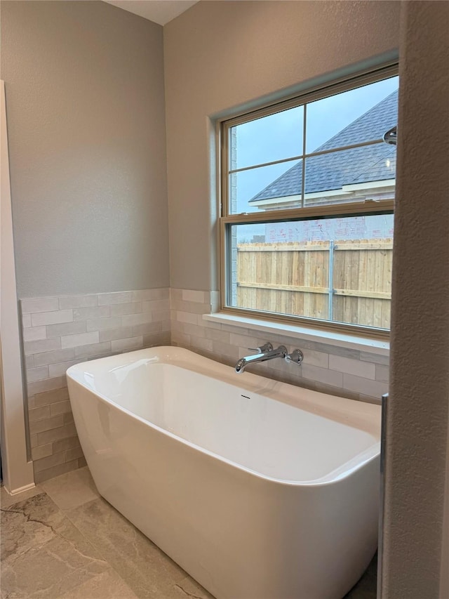 bathroom featuring a tub and tile walls