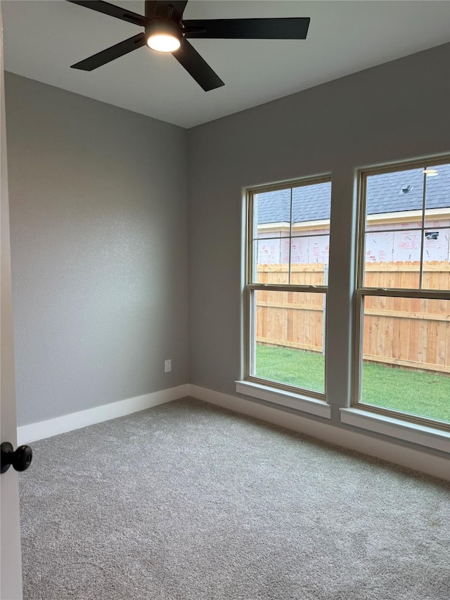 carpeted spare room with ceiling fan