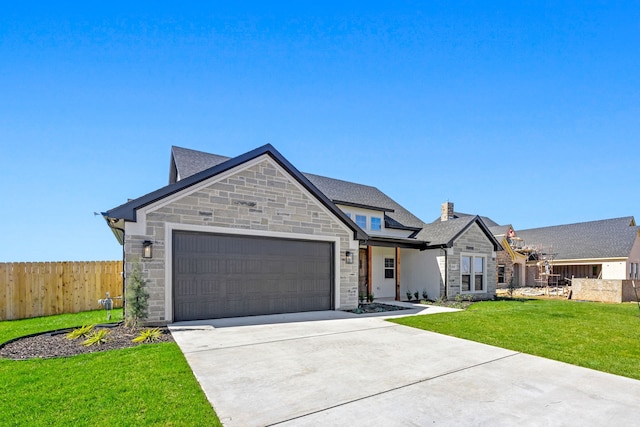 french country style house with fence, concrete driveway, a front yard, stone siding, and an attached garage