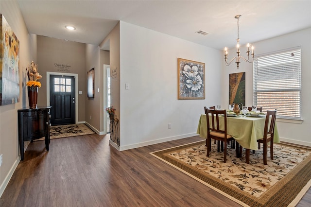 dining area featuring dark hardwood / wood-style flooring and a chandelier