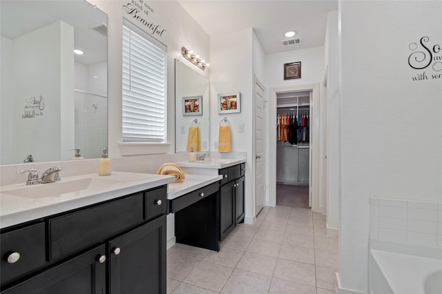 bathroom featuring vanity, tile patterned floors, and a tub to relax in