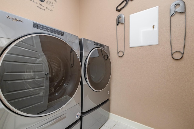 laundry area featuring washing machine and dryer and light tile patterned floors