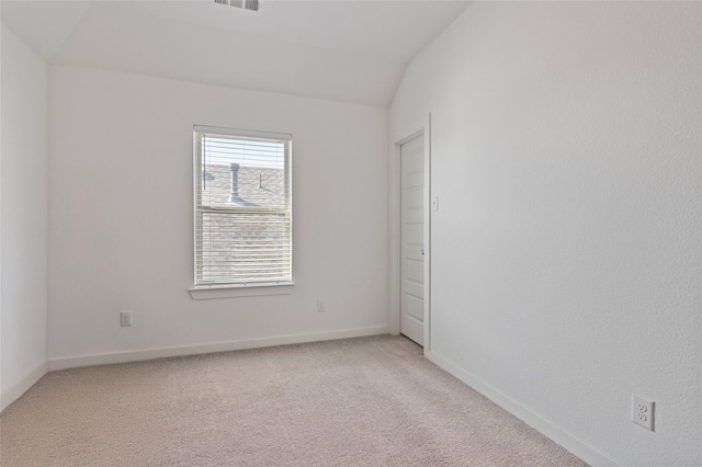 empty room with lofted ceiling and carpet floors