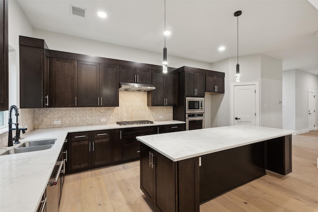 kitchen featuring pendant lighting, dark brown cabinetry, appliances with stainless steel finishes, and sink