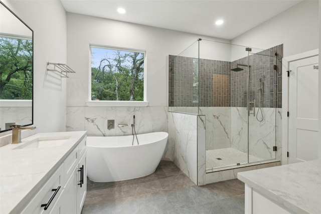 bathroom featuring vanity, plus walk in shower, and tile walls