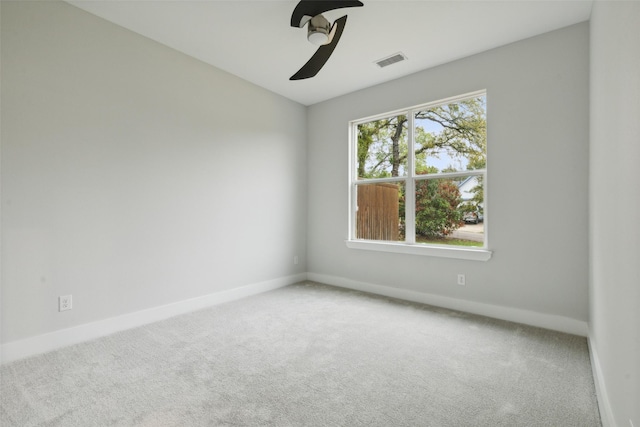 empty room featuring ceiling fan and carpet