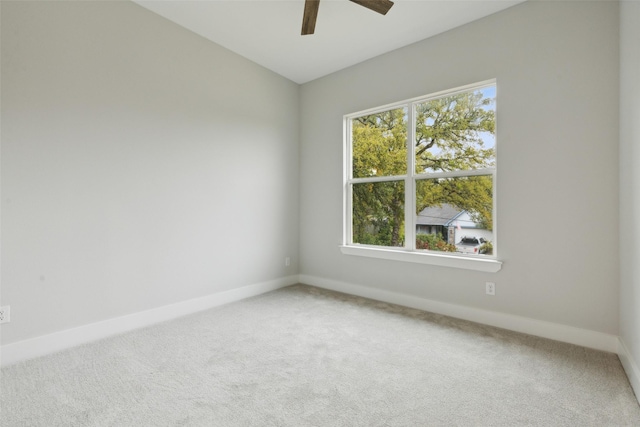 carpeted spare room with ceiling fan