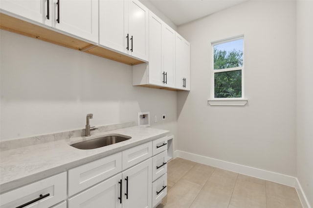 washroom with sink, cabinets, light tile patterned floors, hookup for a washing machine, and hookup for an electric dryer