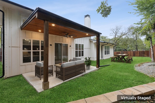 back of property with a yard, outdoor lounge area, a patio, and ceiling fan