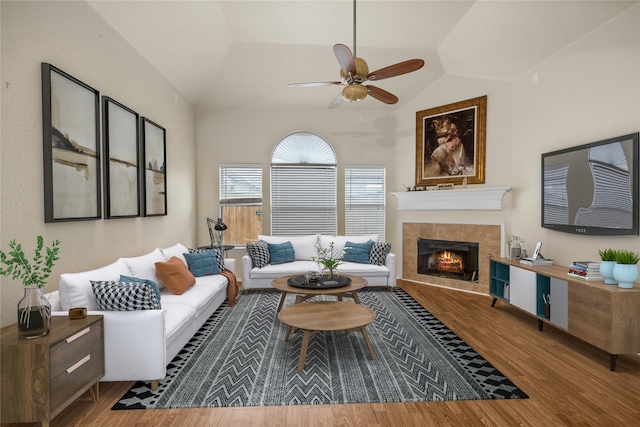 living room featuring lofted ceiling, a fireplace, wood-type flooring, and ceiling fan