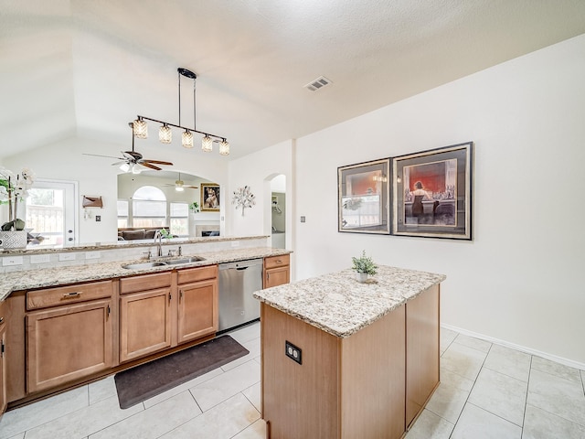 kitchen featuring a kitchen island, dishwasher, sink, hanging light fixtures, and light stone counters