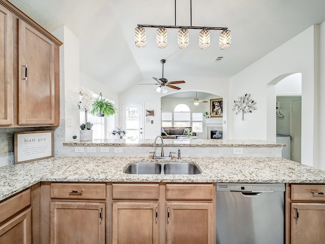 kitchen with sink, light stone counters, hanging light fixtures, dishwasher, and backsplash