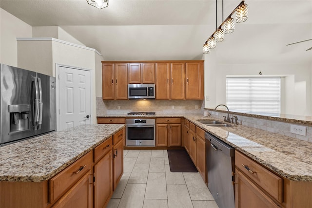 kitchen with pendant lighting, tasteful backsplash, lofted ceiling, sink, and stainless steel appliances