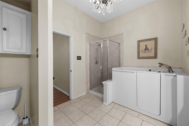 bathroom featuring a chandelier, an enclosed shower, tile patterned floors, and toilet