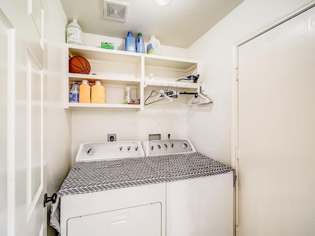 laundry area featuring washer and dryer and a textured ceiling