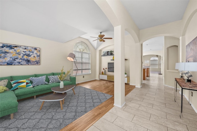 living room featuring ceiling fan, vaulted ceiling, and light hardwood / wood-style flooring