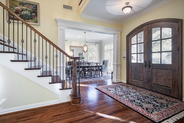 entrance foyer with wood-type flooring, ornamental molding, and french doors