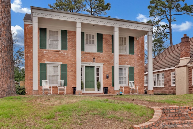 neoclassical home with a front lawn