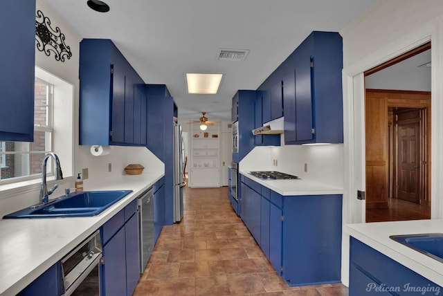 kitchen featuring blue cabinets, stainless steel appliances, and sink