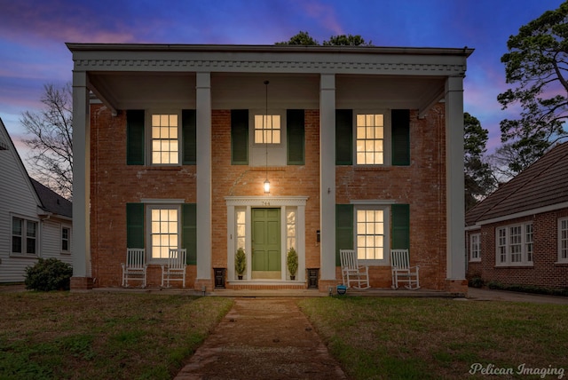 greek revival house with a yard and covered porch