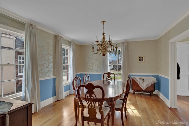 dining area featuring an inviting chandelier, ornamental molding, and light hardwood / wood-style flooring