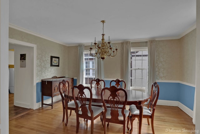 dining area featuring crown molding, plenty of natural light, a chandelier, and light wood-type flooring