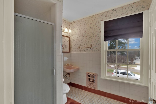 bathroom with tile patterned flooring, tile walls, heating unit, ornamental molding, and toilet