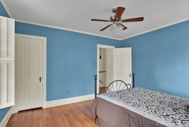 bedroom with ornamental molding, wood-type flooring, and ceiling fan