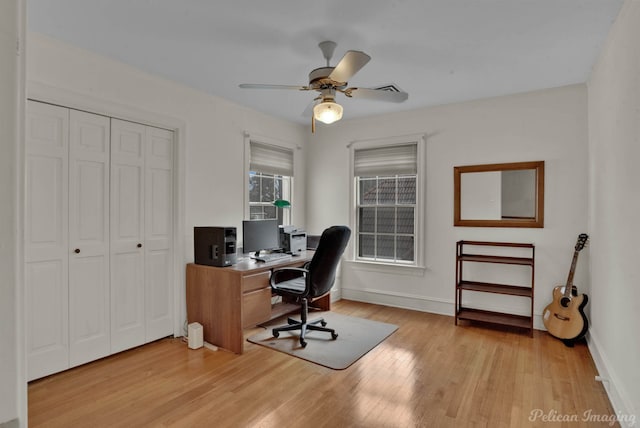 home office with light hardwood / wood-style flooring and ceiling fan