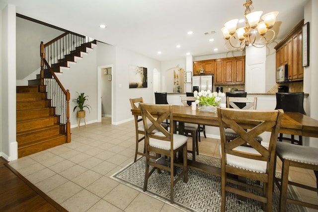 dining room with a chandelier and light tile patterned floors