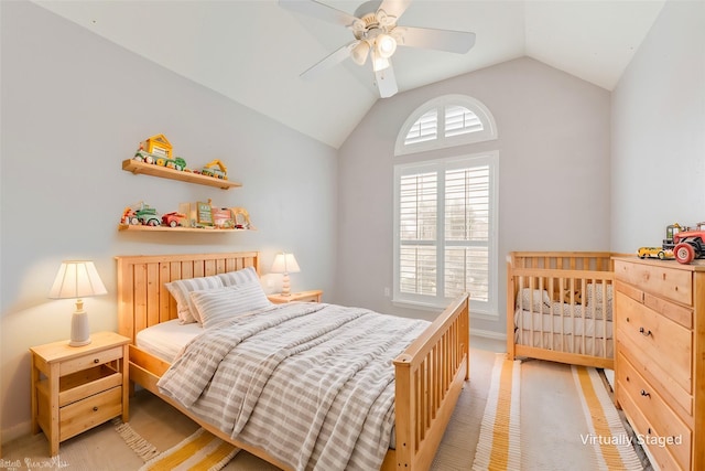 bedroom featuring vaulted ceiling, light colored carpet, and ceiling fan