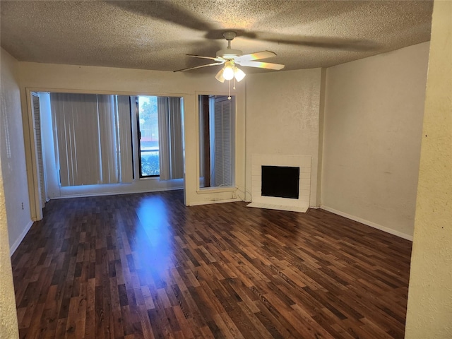 unfurnished living room with a brick fireplace, dark hardwood / wood-style floors, a textured ceiling, and ceiling fan