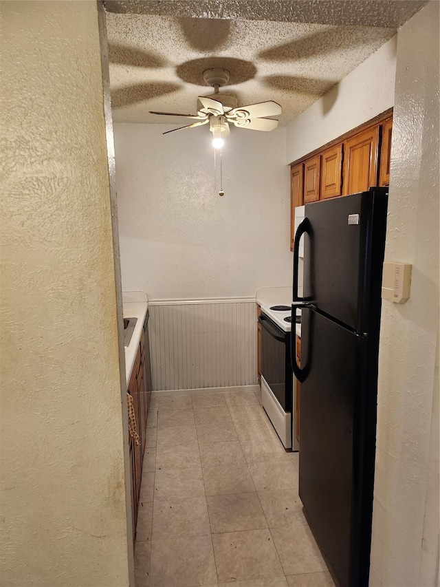 kitchen with black fridge, white electric range, a textured ceiling, and ceiling fan