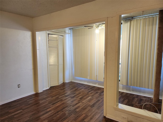 unfurnished room featuring dark hardwood / wood-style floors and a textured ceiling