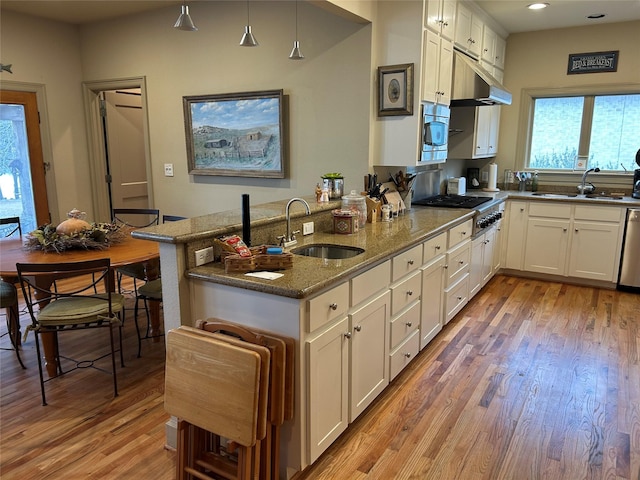 1434 Lakeside Trl, Whitney, TX 76692 - kitchen with stone counters, appliances with stainless steel finishes, sink, white cabinets, and kitchen peninsula