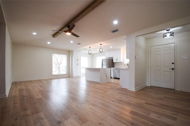 unfurnished living room featuring light hardwood / wood-style floors, ceiling fan, lofted ceiling with beams, and sink